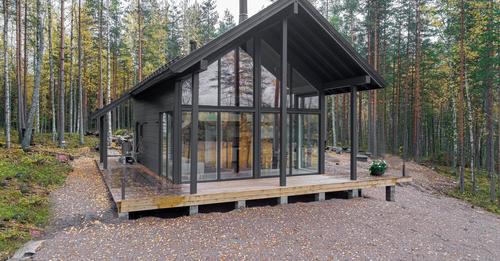 -loft-like-interior-a-wraparound-deck-and-a-gable-outline-reminiscent-of-a-traditional-log-cabin.