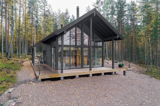 -loft-like-interior-a-wraparound-deck-and-a-gable-outline-reminiscent-of-a-traditional-log-cabin.